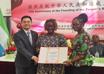 The Chinese Ambassador to Sierra Leone, Ambassador Wang Qing and the Minister of Technical and Higher Education, Dr. Haja Ramatulai Wurie, presenting a certificate to one of the Grant Recipient
