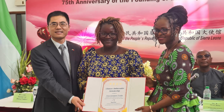 The Chinese Ambassador to Sierra Leone, Ambassador Wang Qing and the Minister of Technical and Higher Education, Dr. Haja Ramatulai Wurie, presenting a certificate to one of the Grant Recipient