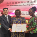 The Chinese Ambassador to Sierra Leone, Ambassador Wang Qing and the Minister of Technical and Higher Education, Dr. Haja Ramatulai Wurie, presenting a certificate to one of the Grant Recipient